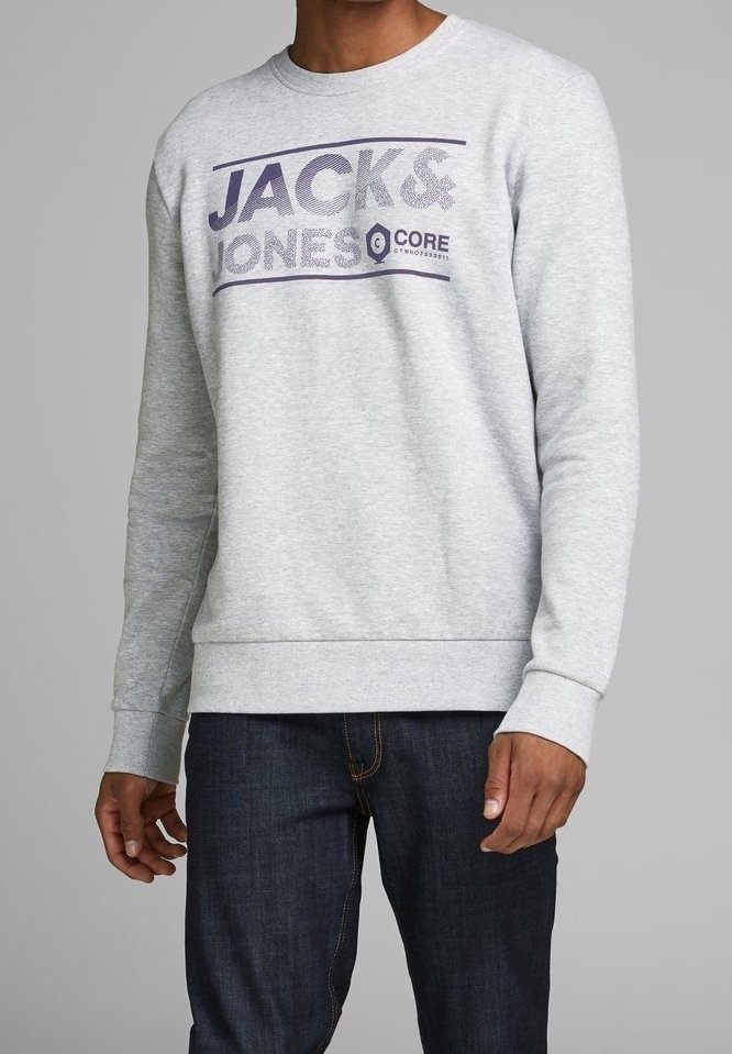 Felpa grigia in cotone con polsini e orlo a costine. Presenta il logo "JACK & JONES" in viola sul petto. Abbinata a jeans scuri.