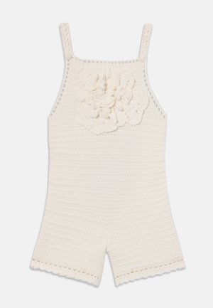 Mono de ganchillo en color crema, con tirantes finos, un acento floral texturizado y bordes en forma de concha en los pantalones cortos para un detalle adicional.