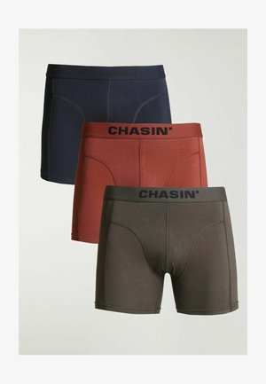 Tre paia di boxer Chasin' nei colori blu navy, ruggine e verde scuro. Tutti presentano una vita elasticizzata con il nome del marchio in nero.