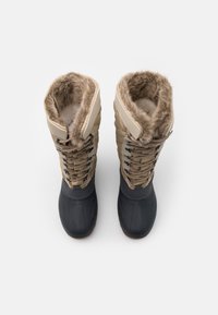 Brune og sorte vinterstøvler med kunstpelsforing, snørebåndsdesign, gummisåler og tekstiler til isolering og greb.