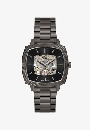 Męski zegarek Fossil ze stali nierdzewnej z czarną, teksturowaną, kwadratową ramką, szkieletem tarczy ukazującym mechanizm oraz metalową bransoletą z ogniw.