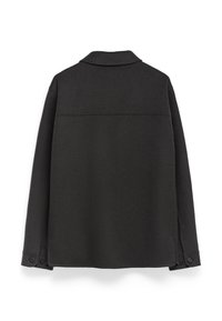 Czarna kurtka koszulowa z mieszanki wełny, z kołnierzykiem, długimi rękawami i zapięciem na guziki. Posiada prosty, minimalistyczny design z tyłu.