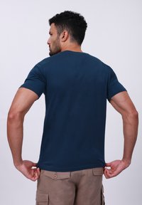 Camiseta de manga corta en azul marino, confeccionada en una suave mezcla de algodón, con un cuello redondo clásico y un ajuste relajado, con un diseño liso en la parte posterior.