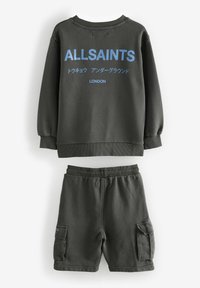 Mörkgrönt set med bomullströja och shorts, med blått "ALLSAINTS"-logotyp på baksidan av tröjan och cargofickor på shortsen.