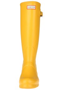 Botte de pluie en caoutchouc jaune, hauteur genou, avec un bout arrondi, finition lisse et un détail de sangle en haut. Étiquette de marque à l'avant.