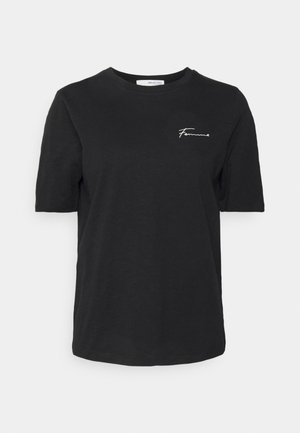 T-shirt noir à manches courtes col rond avec texte manuscrit blanc "Femme" sur la poitrine gauche.
