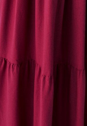 Tissu bordeaux avec une finition douce et texturée. Présente des détails froncés à la taille, créant une silhouette fluide.