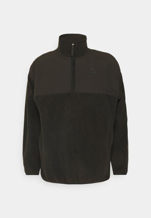 Black fleece pullover with a high collar, half-zip closure, and tonal logo detail on the chest. Features a textured finish.