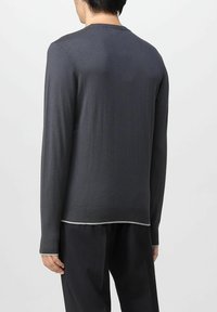 Maglione grigio a maniche lunghe con collo rotondo, orlo e polsini a costine. Texture liscia e cuciture bianche a contrasto sul bordo inferiore.