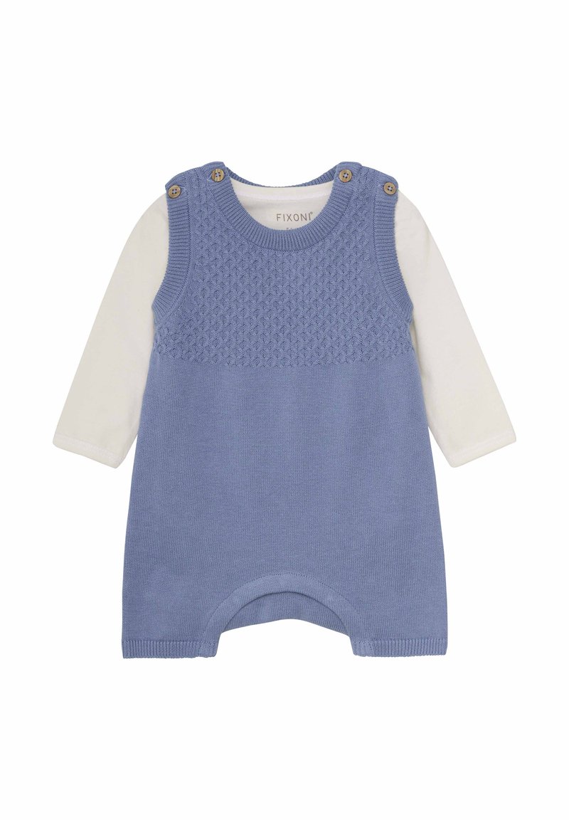 Lyseblå strikket jumpsuit med tekstureret øverste sektion, der har knapdetaljer på skuldrene og en hvid langærmet skjorte underneden.