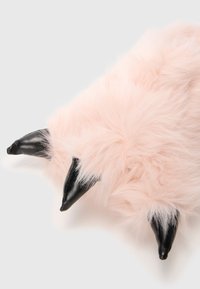 Ροζ ψεύτικη γούνα προϊόν με μαύρες δερματώδεις άκρες. Μαλακή υφή, στρογγυλή μορφή, λεπτομερής όψη γούνας. Δεν υπάρχουν ορατά πρόσθετα χαρακτηριστικά.