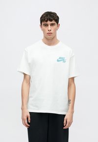 Λευκό βαμβακερό μπλουζάκι με στρογγυλή λαιμόκοψη και κοντά μανίκια. Διαθέτει μπλε λογότυπο Nike SB στο αριστερό στήθος. Απλός και άνετος σχεδιασμός.