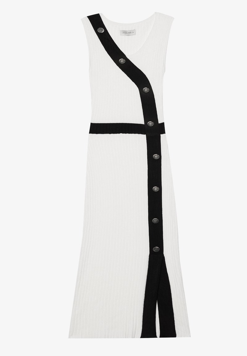 Sukienka dzianinowa z białym korpusem, czarnym ukośnym paskiem, srebrnymi guzikami, dekoltem w serek oraz rozporkiem z boku dla dodatkowego wyróżnienia.
