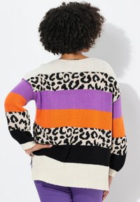 Strickpullover mit horizontalen Streifen in Orange, Lila und Schwarz; weist ein Leopardenmuster auf und hat eine übergroße, lässige Passform.