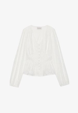 Blouse blanche à manches longues, col rond, et fermeture à boutons. Présente une texture florale subtile et un ourlet peplum pour une silhouette accentuée.