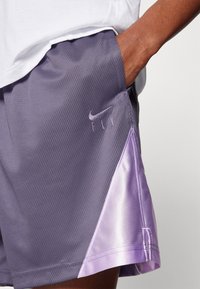 Nike-shorts met een gestructureerde grijze stof en een paarse satijnen accenten aan de zoom. Met het "FLY"-logo in bijpassend paars.