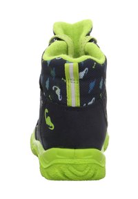 Scarpe per bambini nere e verdi con una suola testurizzata, colletto imbottito e una stampa colorata che presenta piccole forme simili a dinosauri.