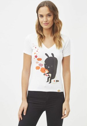 Camiseta de algodón blanca con cuello en V que presenta un gráfico colorido de un niño y una criatura negra, con acentos de naranja y rojo en la obra.