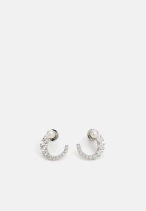 Orecchini in tonalità argento con un design curvo, decorati con cristalli trasparenti e un accento di perla. Leggeri e con una finitura lucida.