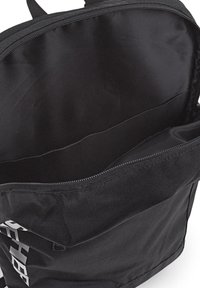 Interior de mochila negra con cierre de cremallera, que presenta una textura de tela suave y múltiples compartimentos para la organización.