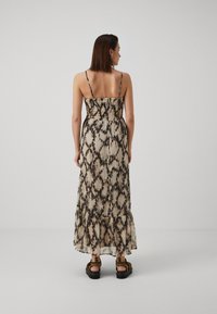 Maxi kleit peenikeste rihmadega, volangist bodice ja kihiline hem. Omaduseks beez ja must triibuline muster. Kerge kangas, voolav disain.