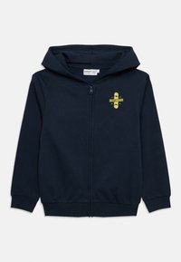 Námornícka tmavomodrá mikina na zips z bavlny, na hrudi so žltou grafikou skateboardu. Obsahuje klokanie vrecko a rebrované manžety.