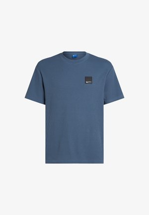 Sinine ribaga lühikeste varrukatega T-särk, mille vasakul rinnal on ruudukujuline must silt. Valmistatud tekstureeritud kangast, ümar kaelus.