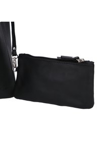 Portefeuille en cuir noir avec une texture lisse, fermeture zippée en haut et une dragonne détachable. Forme rectangulaire compacte.