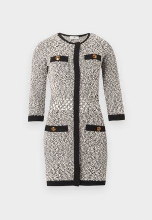 Μαύρο και λευκό φόρεμα από τουίντ μέχρι το γόνατο με μακριά μανίκια, μαύρο τελείωμα, τέσσερις τσέπες με μαύρο τελείωμα και χρυσά κουμπιά.