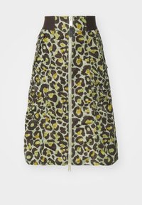 Polstret skjørt med brun, grønn og gulflekket leopardmønster. Har glidelås foran, elastisk midje og to stikklommer.