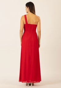 Maxikleid in Rot mit gerafftem Oberteil und einem schmalen Träger, dazu einem fließenden Rock und glatter Textur.