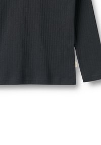 Haut à manches longues noir gris, côtelé, avec un ourlet droit et une texture subtile. Présente une petite étiquette de marque sur le côté.