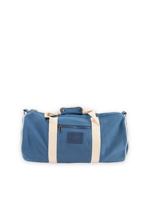 Bolsa de lona azul con asas beige y un bolsillo delantero con cremallera sobre un fondo blanco.