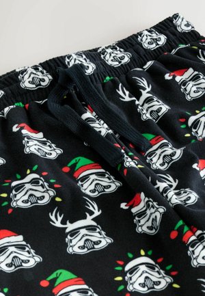 Sorte fleecebukser med gentagne Stormtrooper-ansigter med festlige detaljer som julemandshuer og rensdyrgevir, med snøre i taljen.