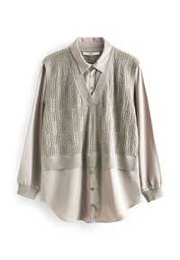 Blusa beige a strati con sovrapposizione di un gilet in maglia, caratterizzata da un collo a V, chiusura con bottoni e motivo testurizzato, completata da maniche lunghe.