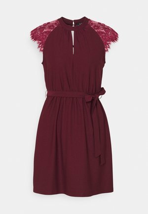 Šaty bez rukávů ve vínové barvě s krajkovými krátkými rukávy, výstřihem na klíček, řaseným pasem a látkovým páskem uvázaným na boku.