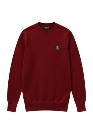 Maglione bordeaux con scollo rotondo, maniche lunghe e piccola toppa rettangolare nera e dorata sul lato sinistro del petto.