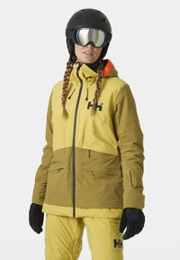 Skijacke mit einem zweifarbigen Design in Gelb und Oliv, aus wasserdichtem Material, mit hohem Kragen und verstellbarer Kapuze.
