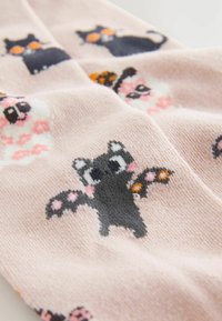 Rosa Stoff mit einem Muster aus verspielten schwarz-weißen Cartoon-Fledermäusen und -Katzen, mit bunten Akzenten und einer sanften Textur.