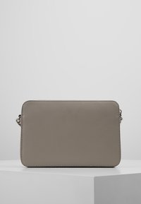 Bolso bandolera de cuero gris con forma rectangular, textura suave y un sutil detalle de costura. Cuenta con una correa desmontable.