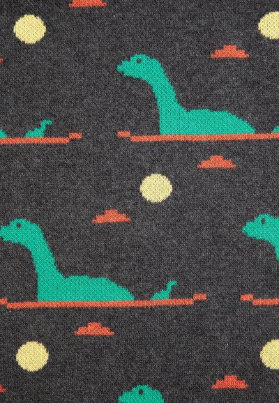 Tissu foncé avec un motif répété de dinosaures verts au long cou, des cercles jaunes ressemblant à des soleils, et de petits nuages rouges.