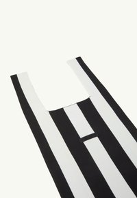 Schwarz-weiße gestreifte Tragetasche mit rechteckiger Öffnung, ausgestattet mit einem strukturierten Stoff und einem kleinen Markenetikett auf der Vorderseite.