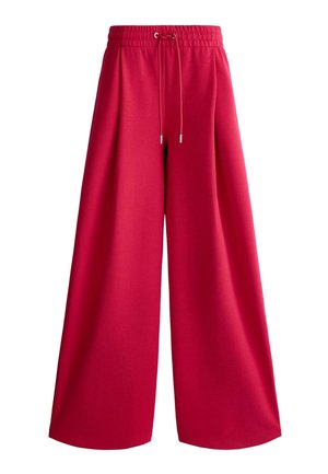Czerwone spodnie o szerokich nogawkach z elastycznym pasem i sznurkiem, wykonane z miękkiego materiału, zaprojektowane z myślą o luźnym kroju.