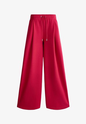 Czerwone spodnie o szerokich nogawkach z elastycznym pasem i sznurkiem, wykonane z miękkiego materiału, zaprojektowane z myślą o luźnym kroju.