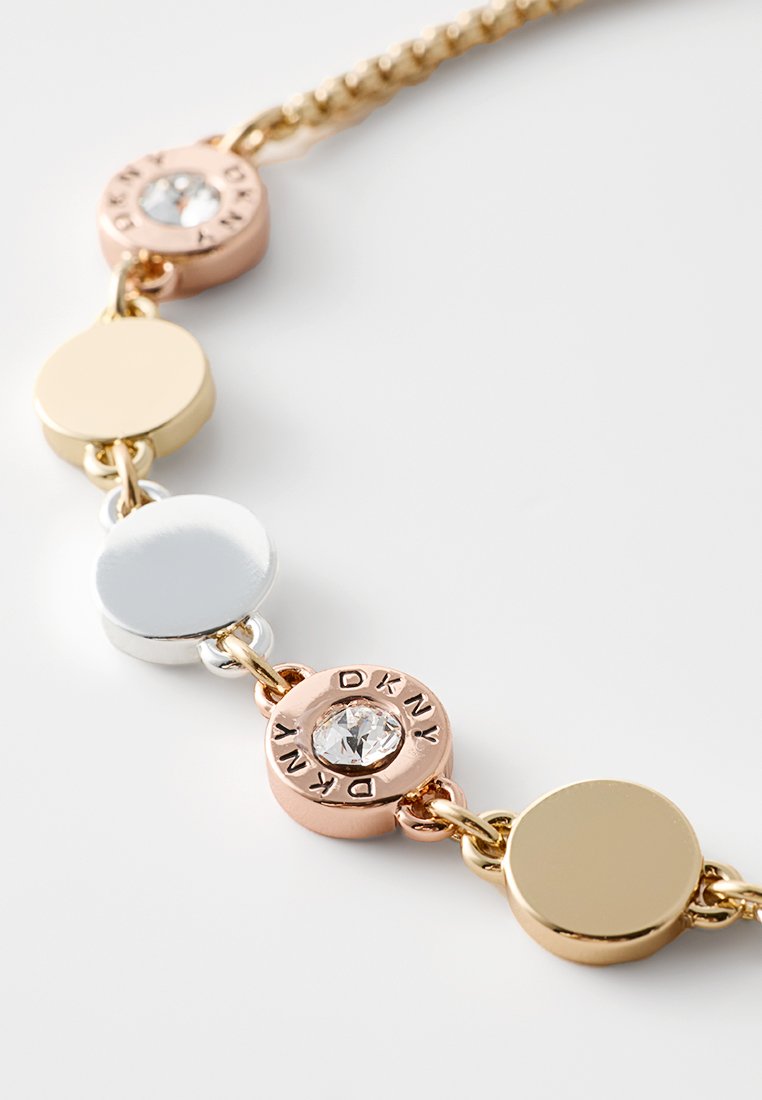 Halskette aus gold- und silberfarbenem Metall mit abwechselnden runden Gliedern und einem Kristallakzent in einer roségoldenen Fassung, versehen mit eingraviertem Branding.