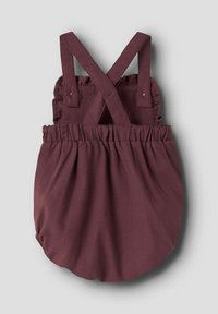 Salopette bordeaux con bretelle incrociate, vita arricciata e fondo arrotondato. Realizzata in un tessuto morbido con una texture liscia.