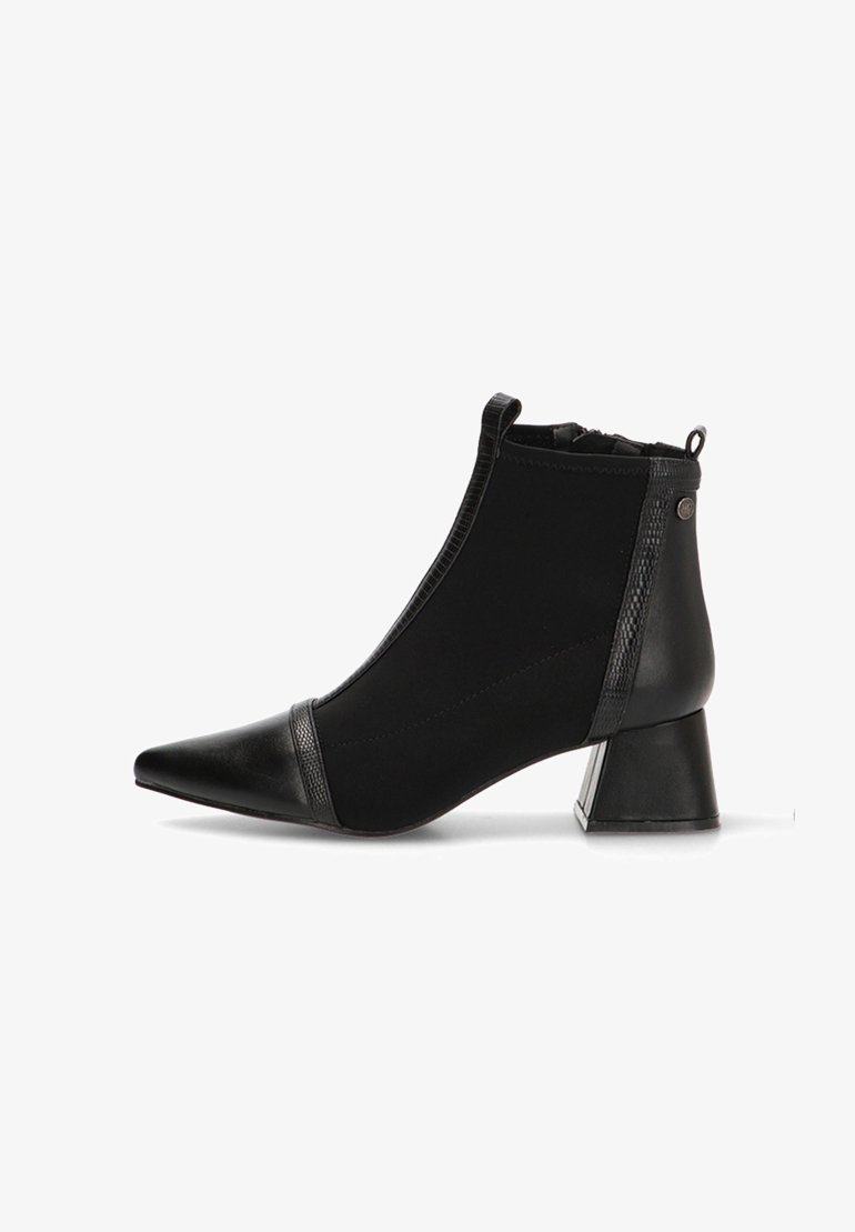 Botín negro con punta afilada, laterales elásticos y un detalle de cuero texturizado cerca de la base. Presenta un tacón cuadrado y un acabado suave.