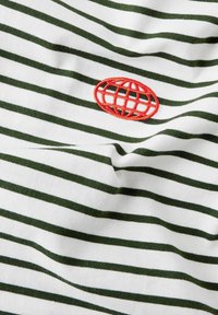 Striped cotton fabric featuring horizontal dark green and white stripes. Red embroidered globe logo prominently displayed on the center.