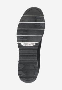 Black rubber shoe sole with textured treads, a silver brand plate, and grooves for traction. Reinforced heel design for stability.