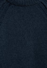 Tengerészkék kötött anyag textúra, puha, bolyhos megjelenéssel. Enyhén kiemelkedő öltésmintával és sima szélekkel.